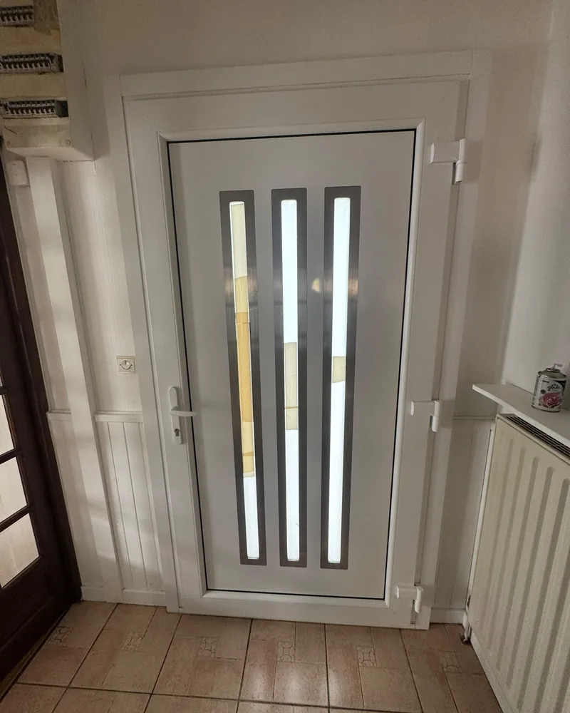 Porte d’entrée blanche à trois bandes vitrées verticales, vue de l’intérieur — photo de chantier