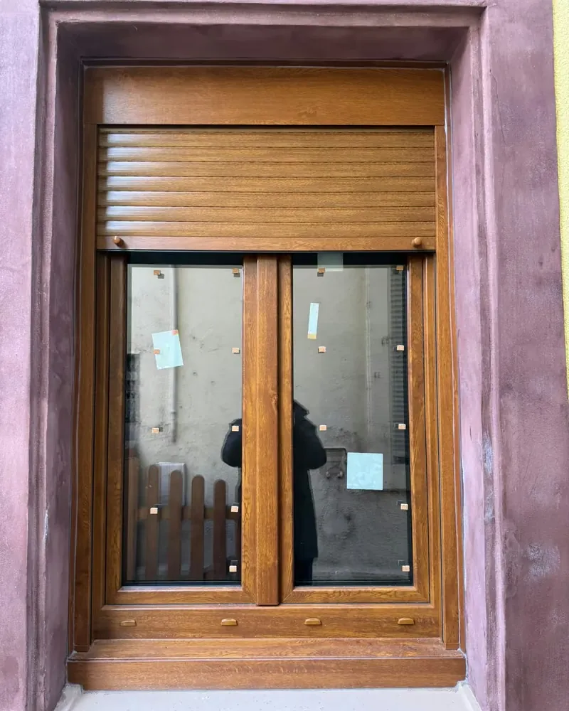 Fenêtre ton bois et volet roulant assorti dans son encadrement, juste après la pose, étiquettes encore sur le vitrage — photo de chantier