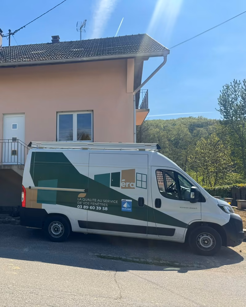 Le fourgon ECO RÉNOV ALSACE garé devant une maison au crépi rose, le jour du chantier — photo de chantier
